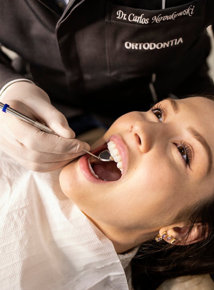 Close-up portrait of a woman receiving a dental checkup in a clinic setting.